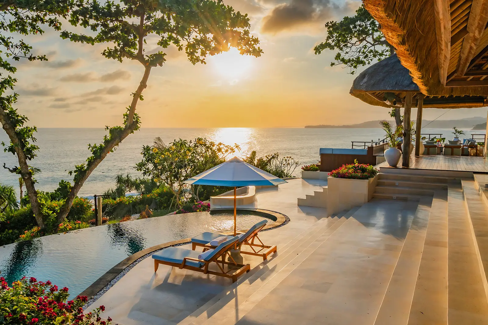 La terrazza di Putri Kasambi al tramonto: la piscina a sfioro, i lettini e il sole sull’oceano