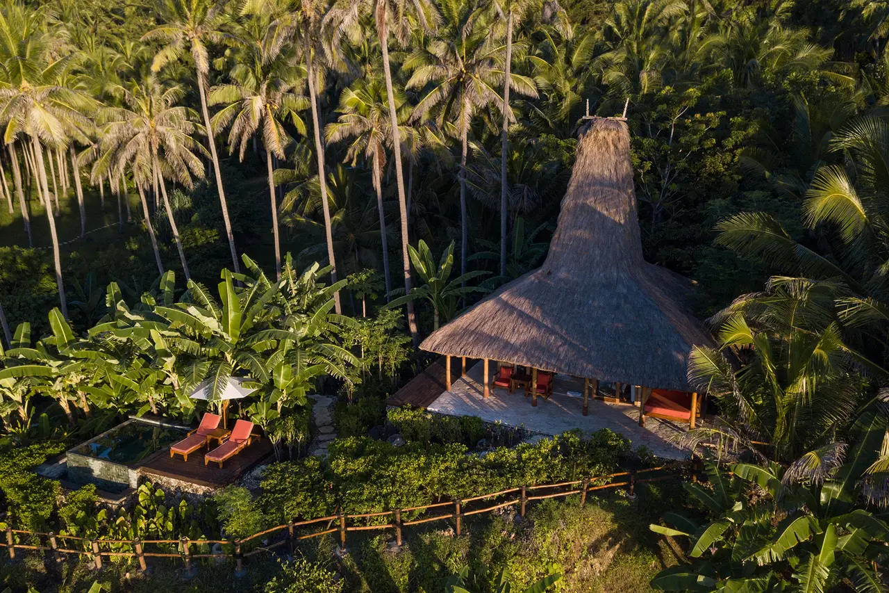 Villa Rahasia dall’alto: il tetto di paglia a punta fra le palme di Nihioka