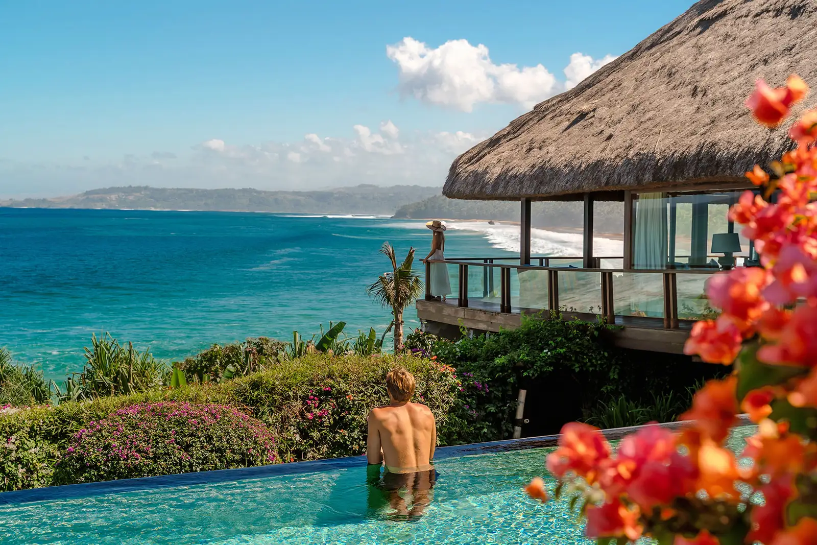 Un ospite nella piscina di Raja Mandaka, fra le buganvillee, con la costa di Sumba alle spalle