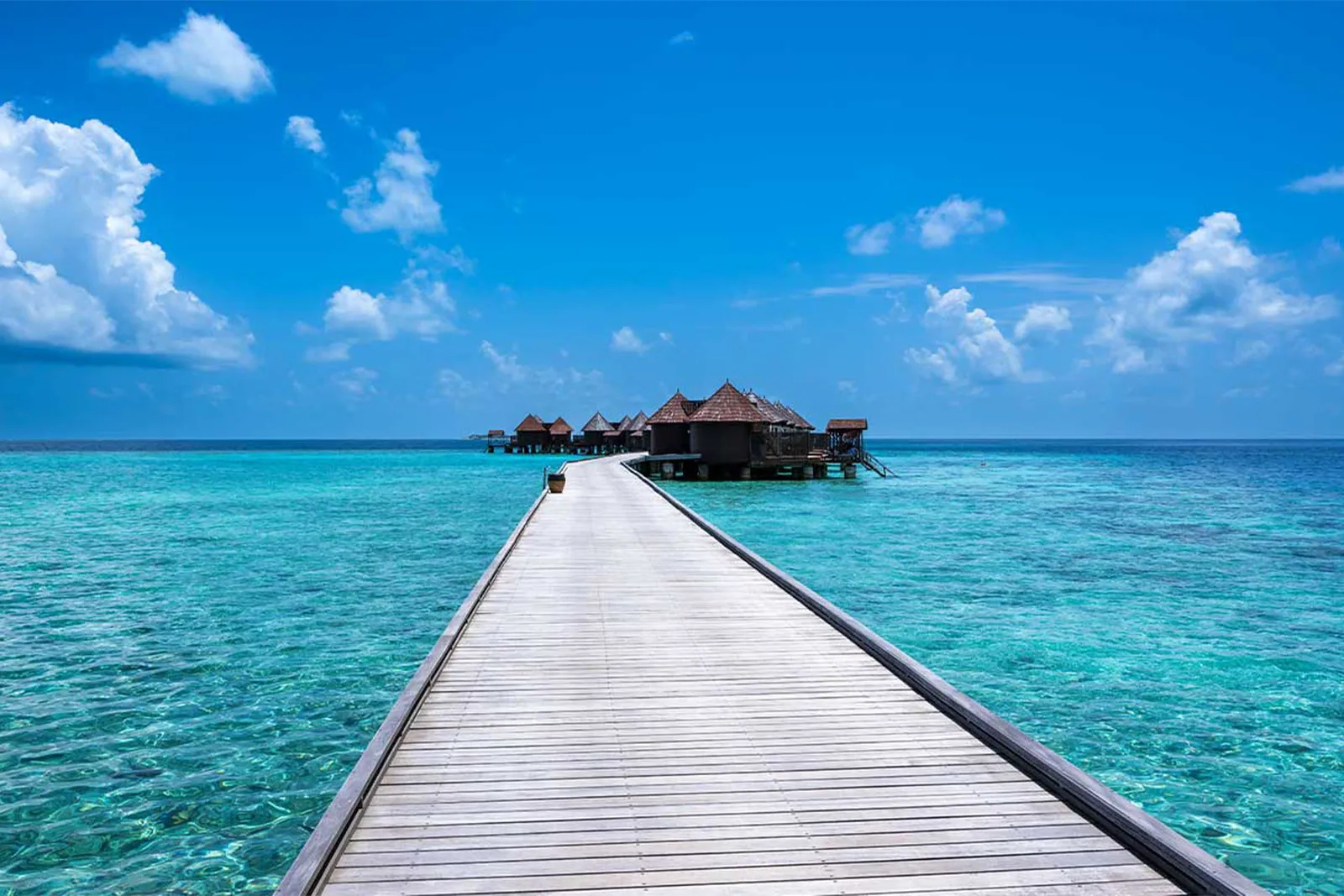 The timber walkway leading out to sea towards the water villas.
