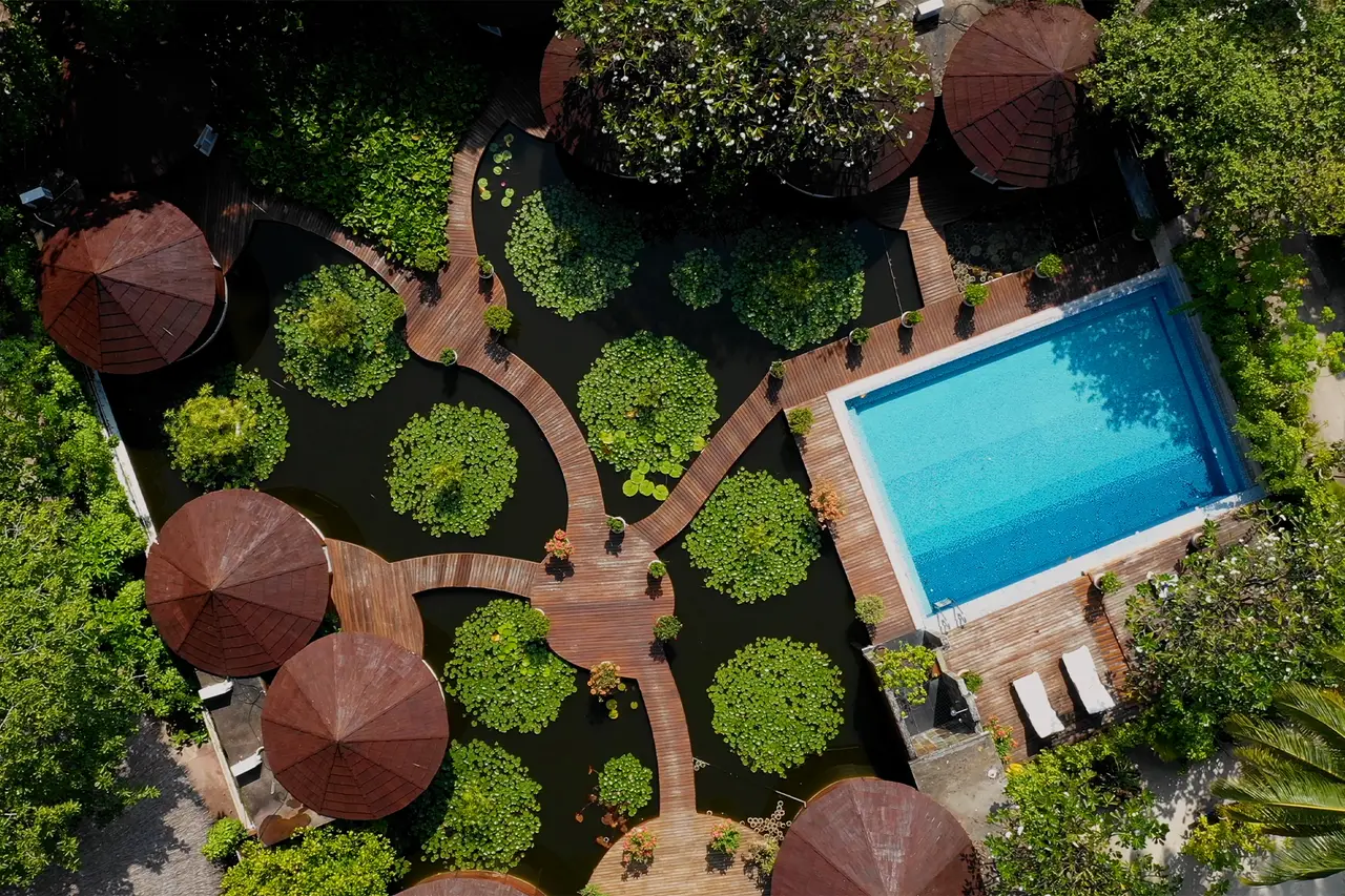 The Lotus Spa from above: round pavilions on a lily pond, timber walkways and a pool with 2 loungers.