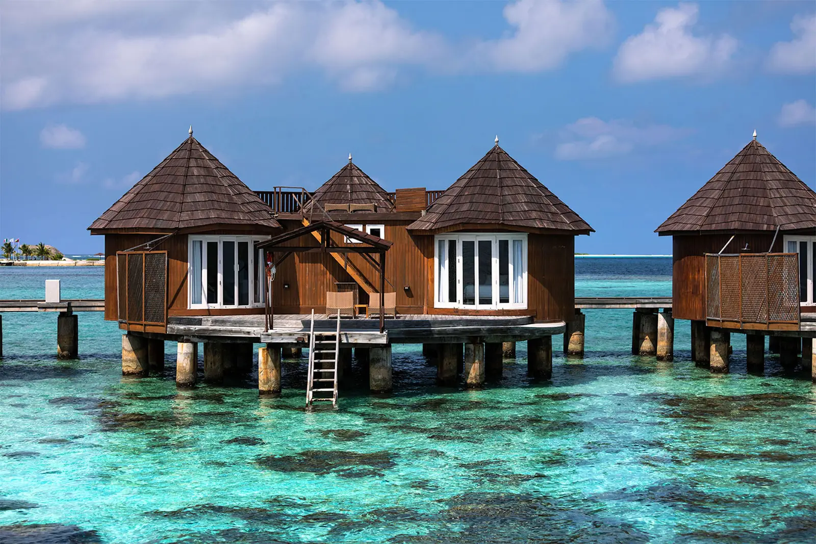 2 timber water villas on stilts, with the ladder going down into the reef.