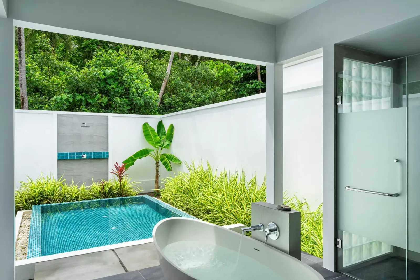 A Beach Villa with Garden Pool’s open-air bathroom: the bath, the shower and the pool in its walled garden.