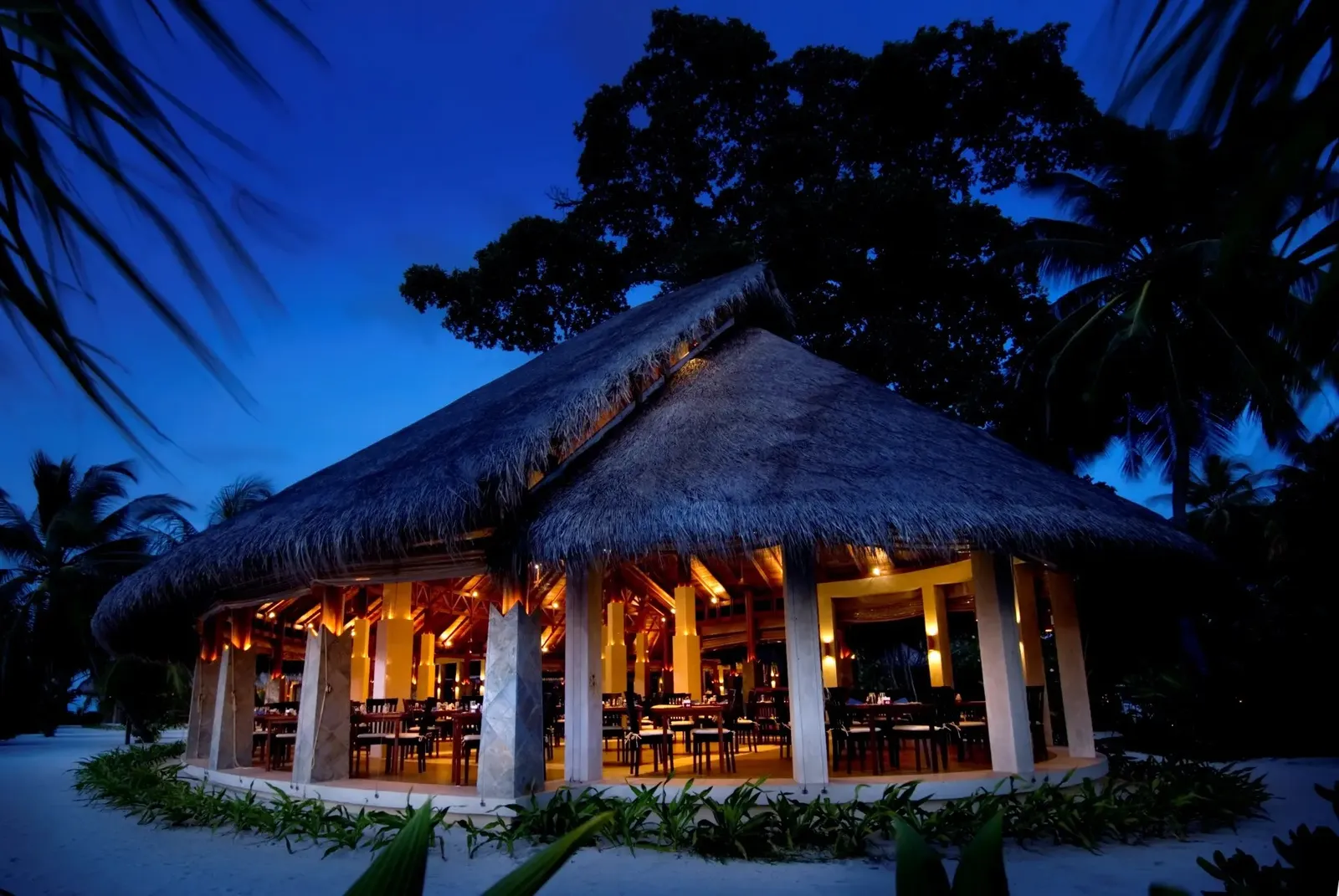 Haruge buffet restaurant at night, its great thatched roof and the lit dining room among the trees