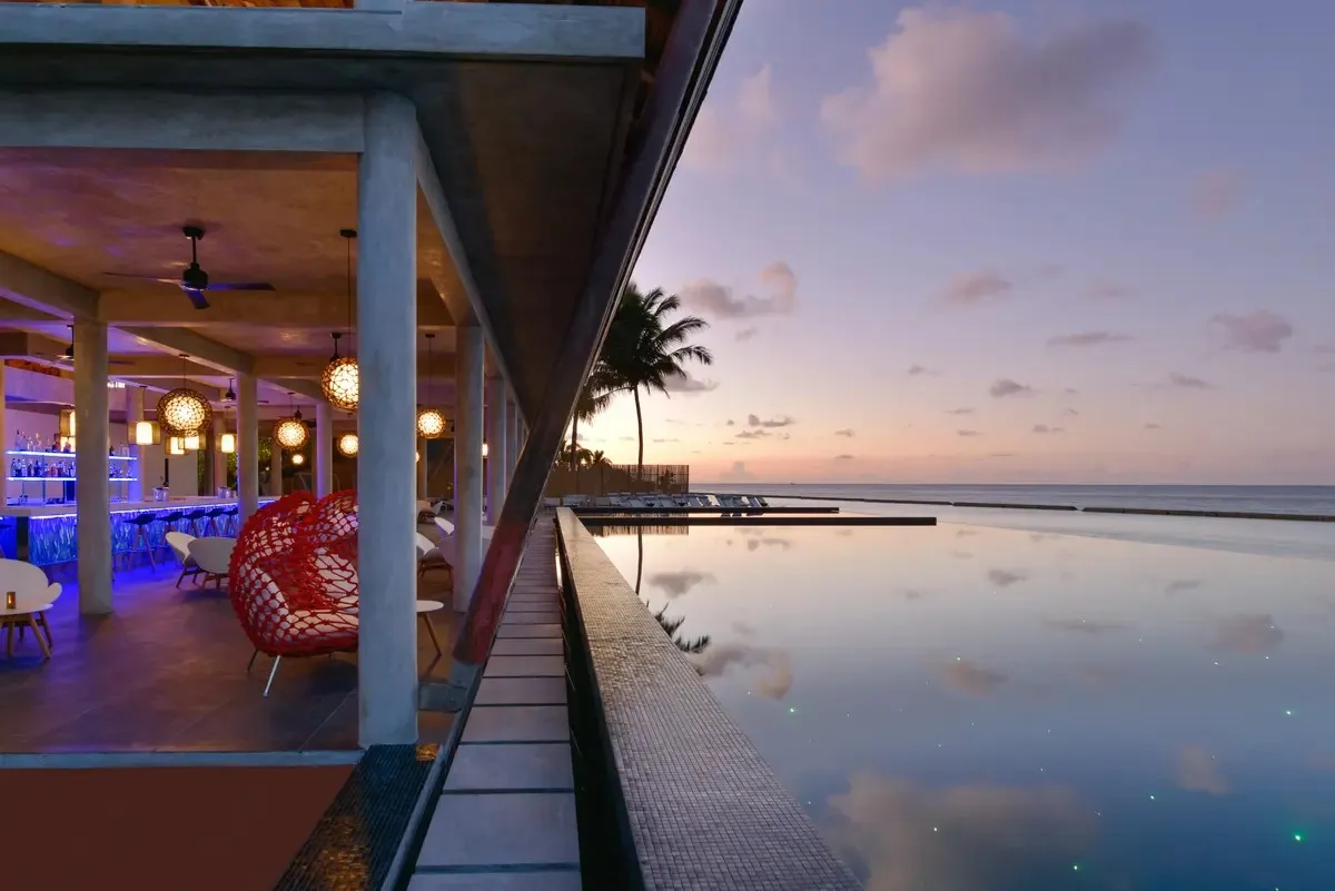 Laguna Bar at sunset, the bar lit blue and the infinity pool reflecting the sky