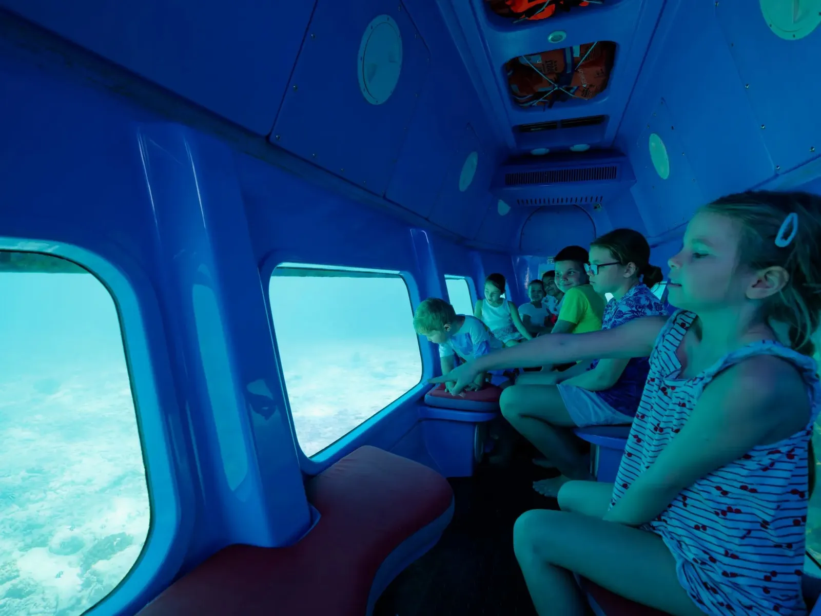 Children at the windows of the semi-submarine, the pale seabed just below