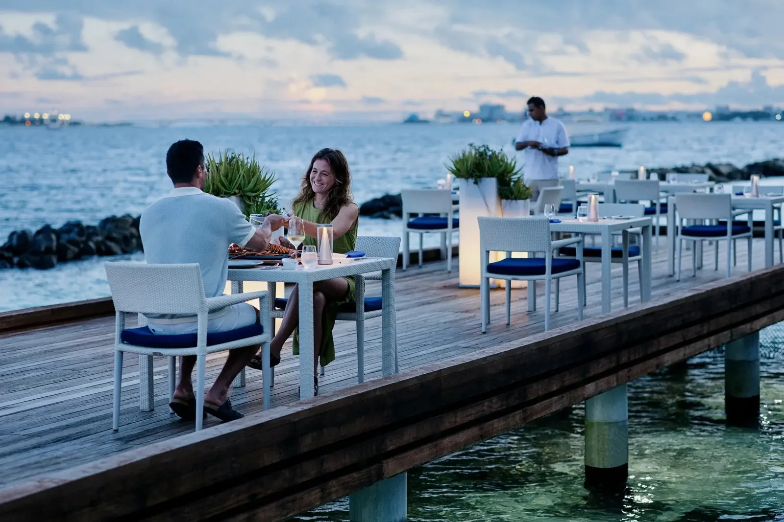 Thila’s deck over the water, a couple at dinner