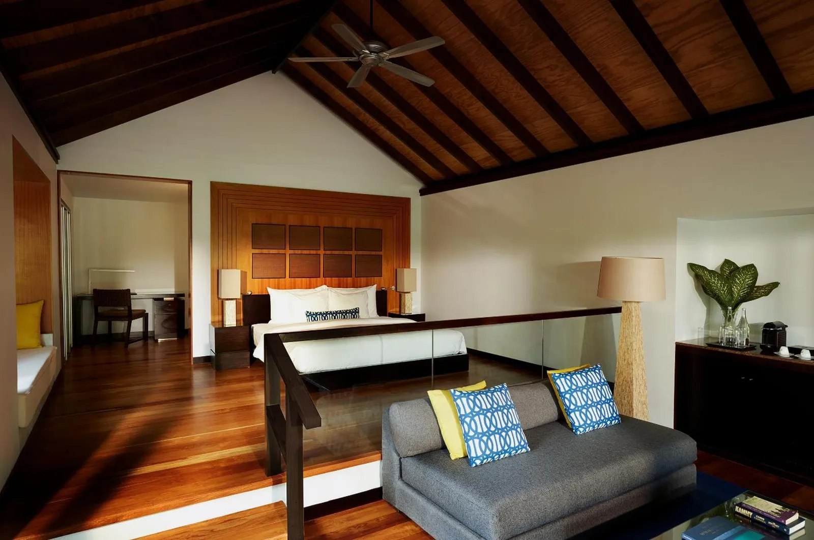 La Deluxe Villa with Pool, con il letto sul livello rialzato e il soggiorno sotto il soffitto a capanna.