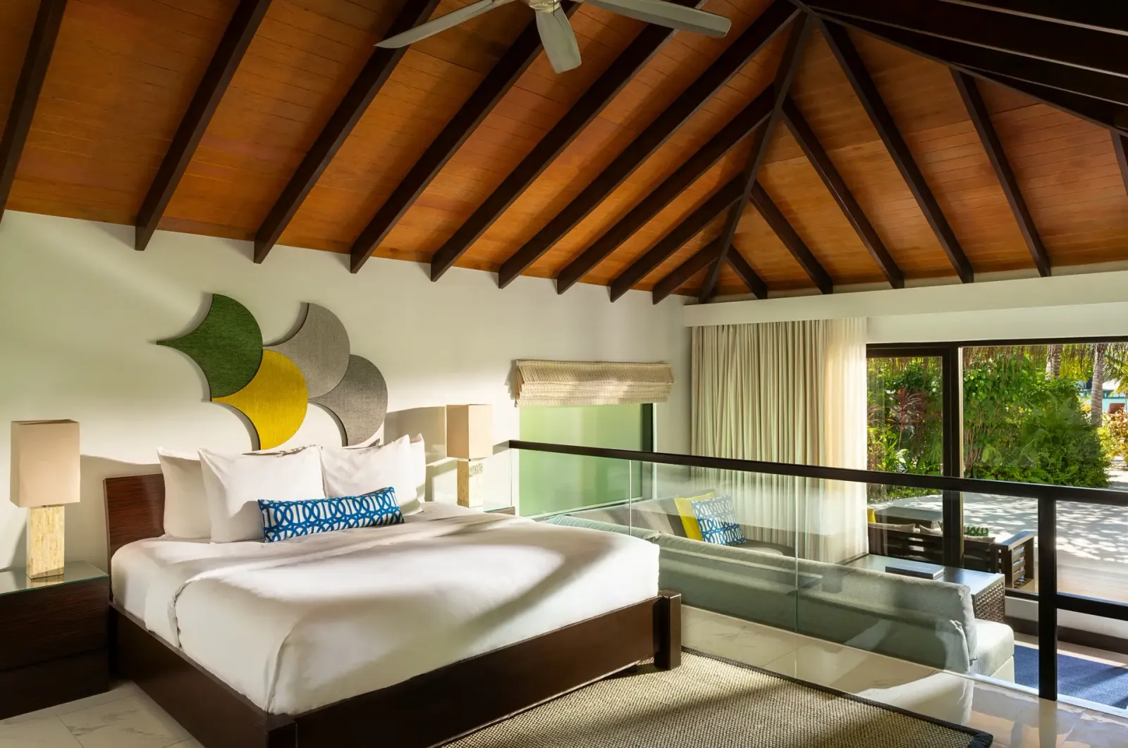 La camera di una Deluxe Villa, il letto king e la vetrata sul giardino: la Two Bedroom ne unisce 2.