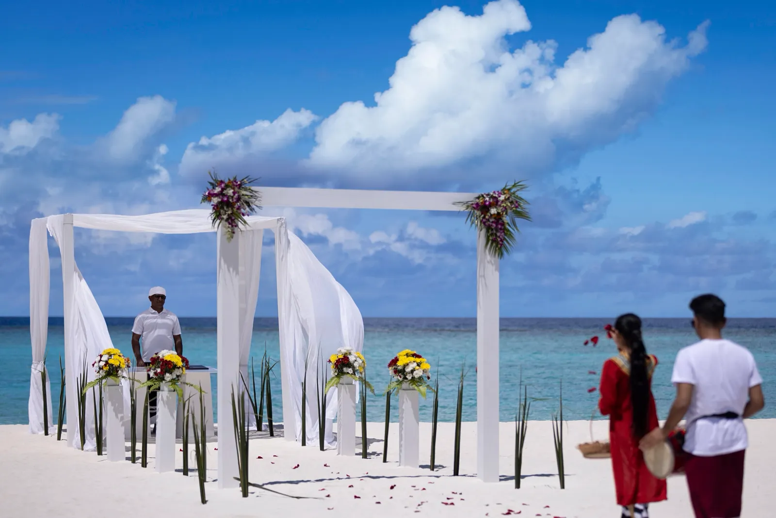 Un rinnovo delle promesse sulla spiaggia: l’arco di fiori, il celebrante e 2 musicisti con il tamburo del boduberu.