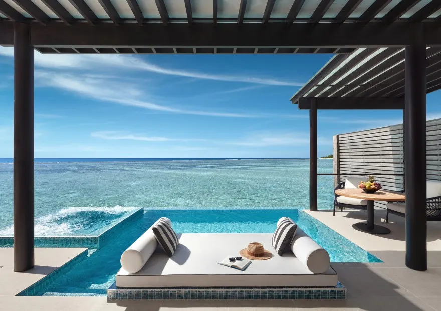 The daybed between the pool and the sea, on the deck of a Deluxe Over Water Pool Villa