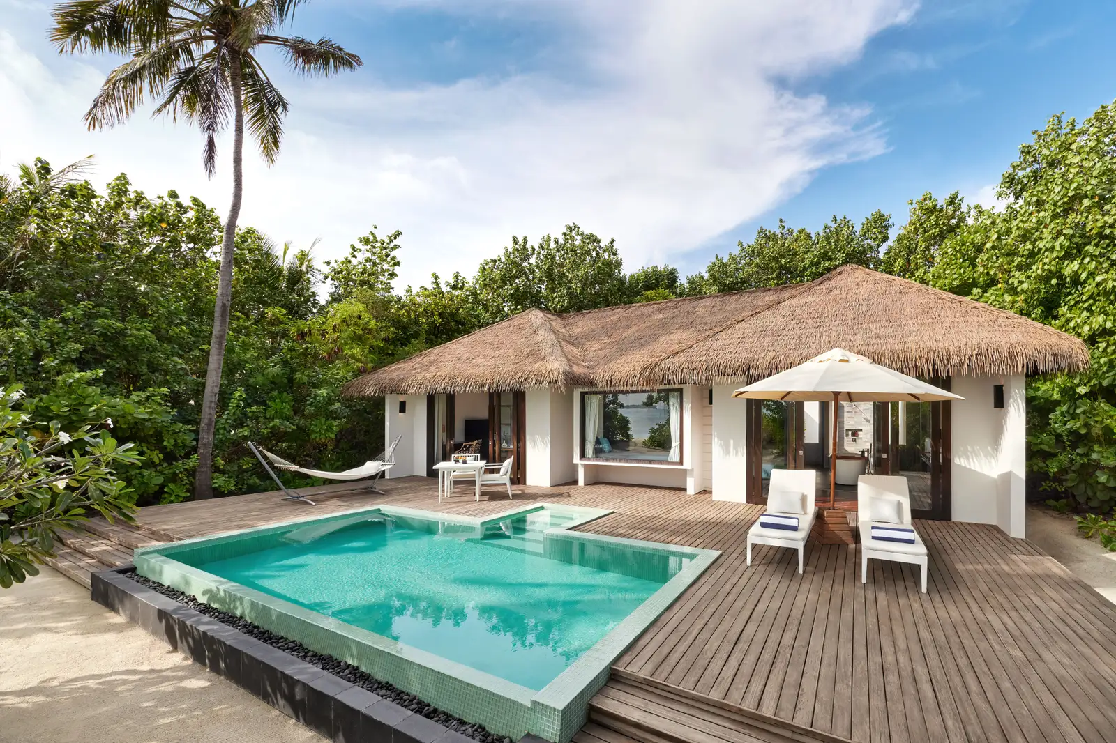 A sunset-side beach villa, with its private pool, loungers and a hammock on the deck among the trees.