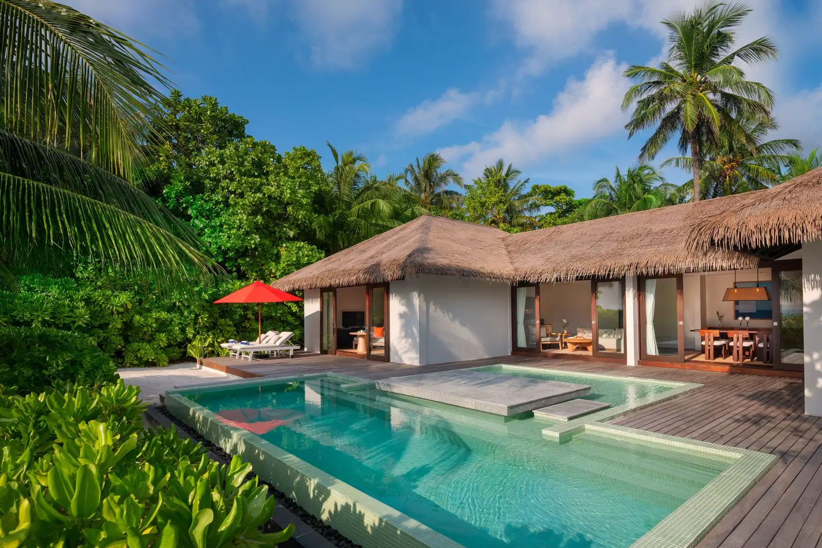 The 2-bedroom beach villa: the thatched pavilion, the pool and the deck among the palms.
