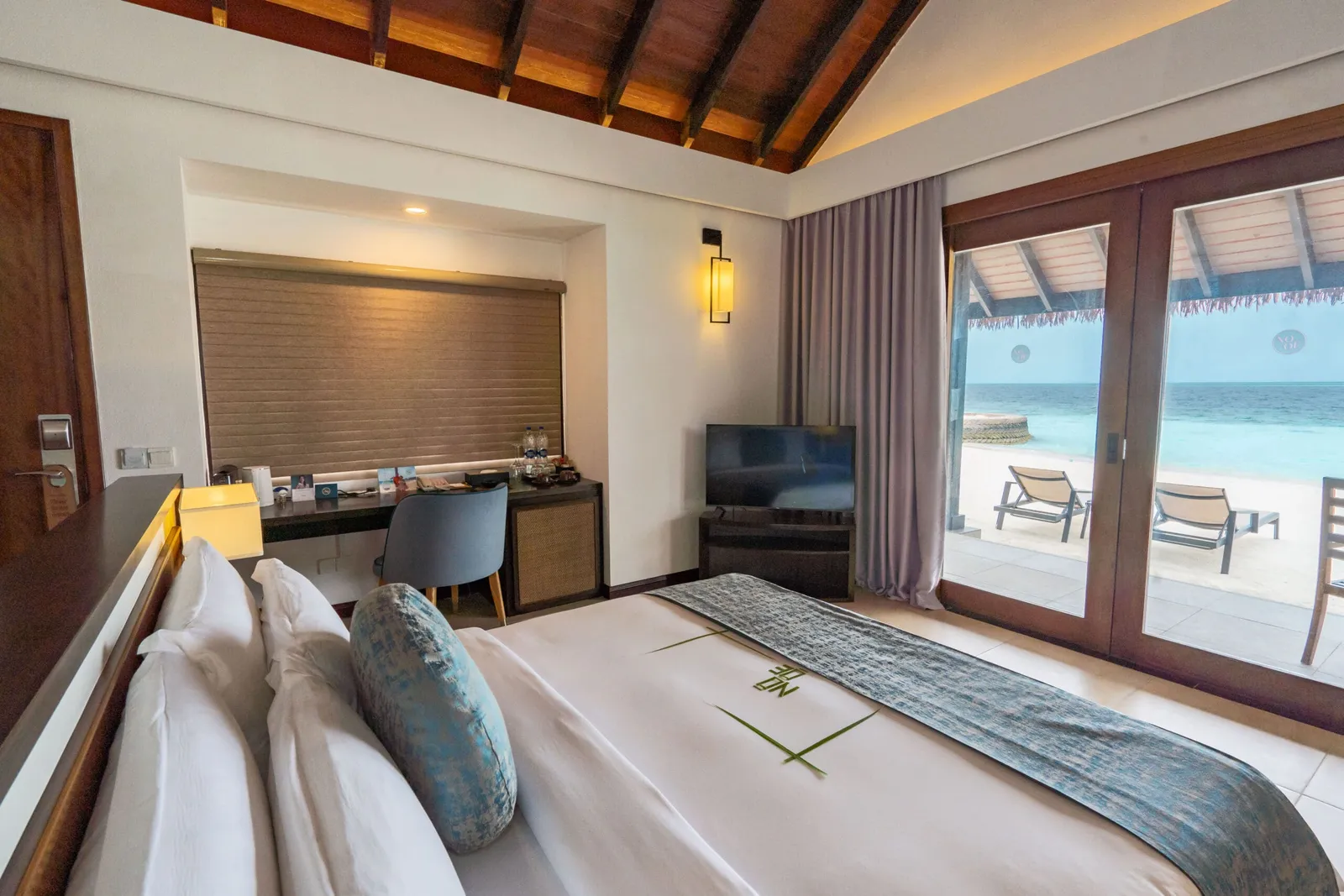 Beach Villa bed and glazed doors towards beach and sea