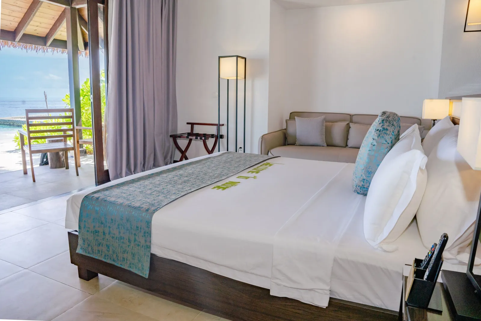 Bed, sofa and covered sea-facing veranda in the Beach Villa