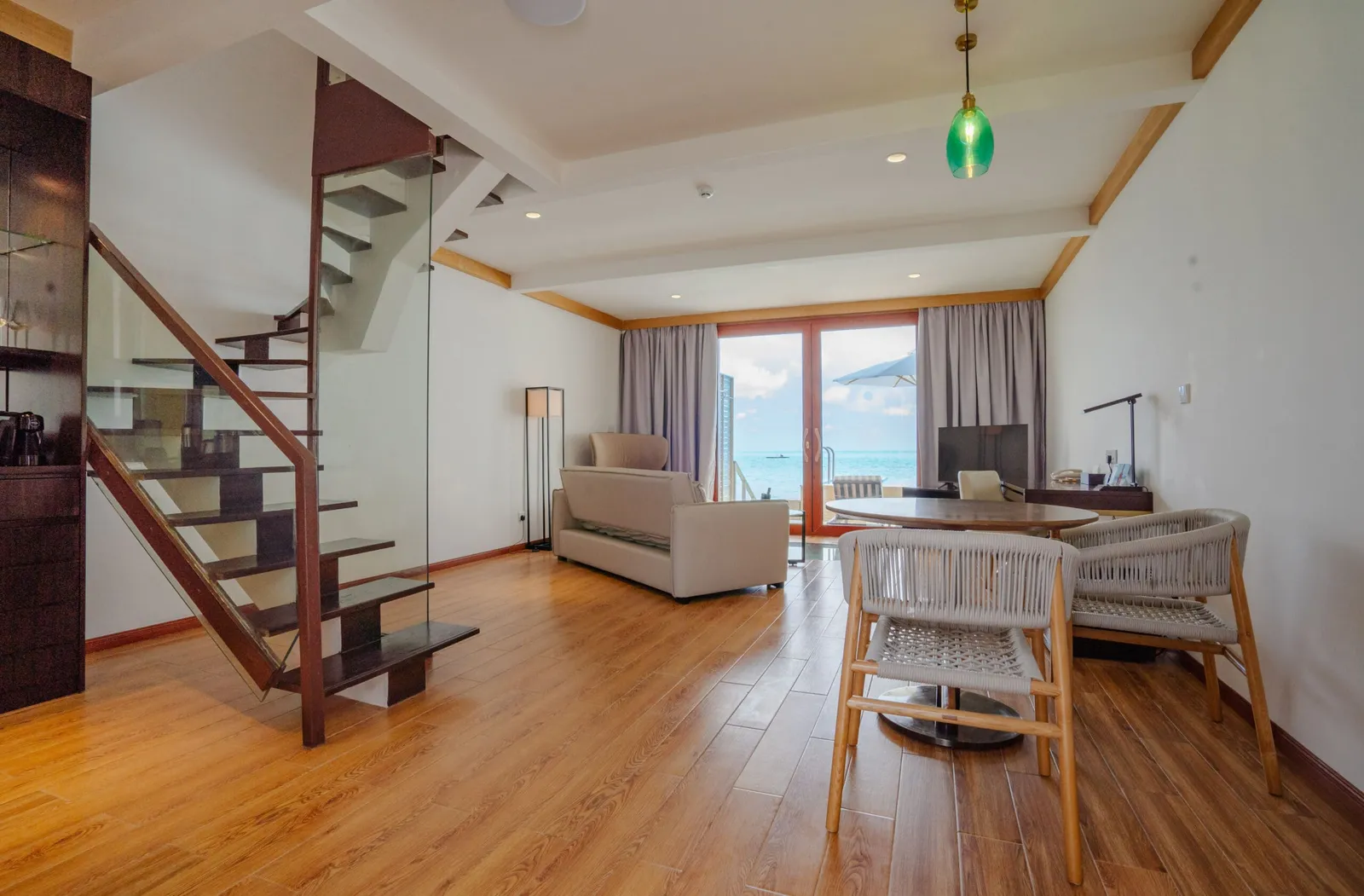 Lounge, table and internal staircase of the Duplex Overwater Villa