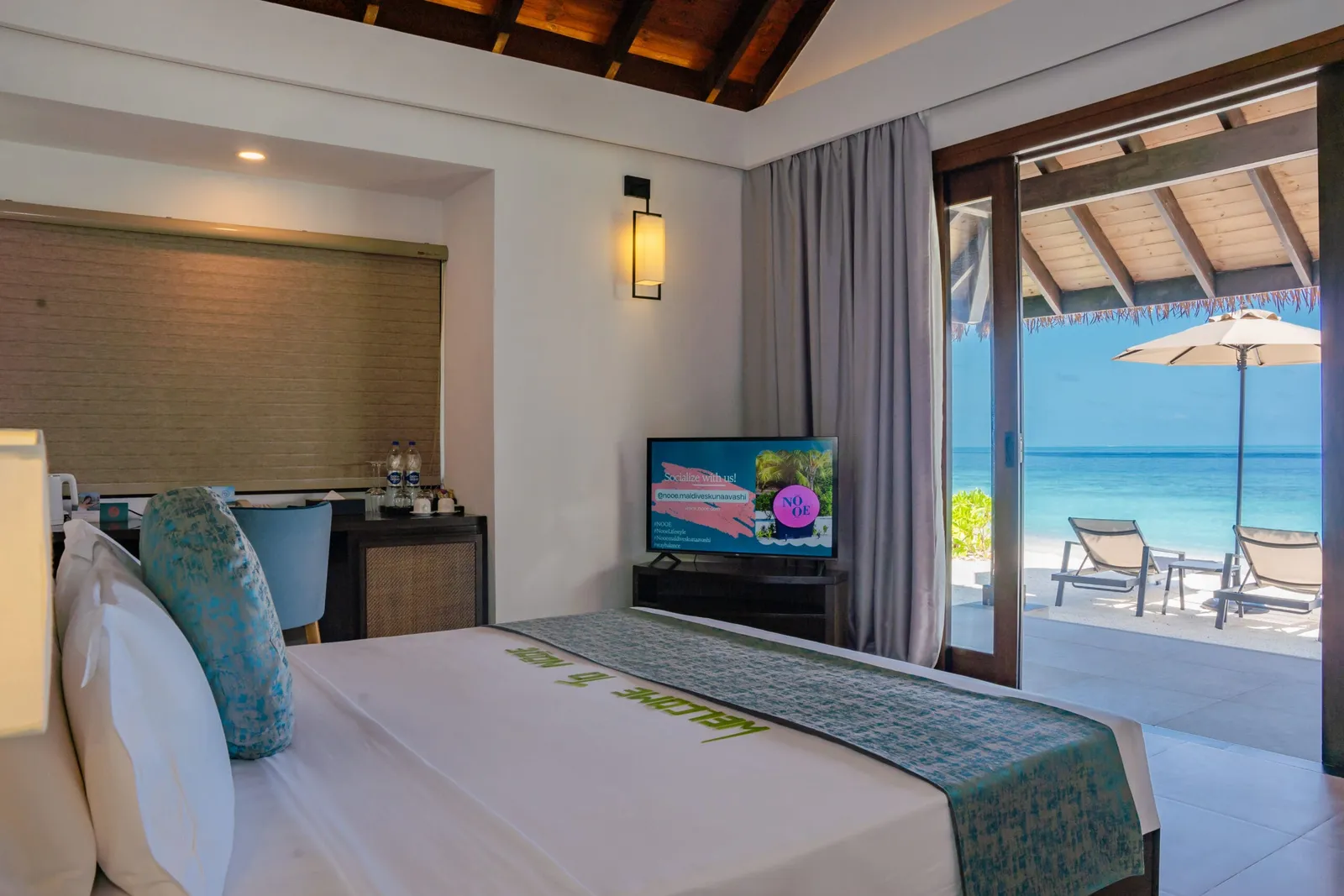 Sunset Beach Villa bedroom and doors towards sea-facing loungers