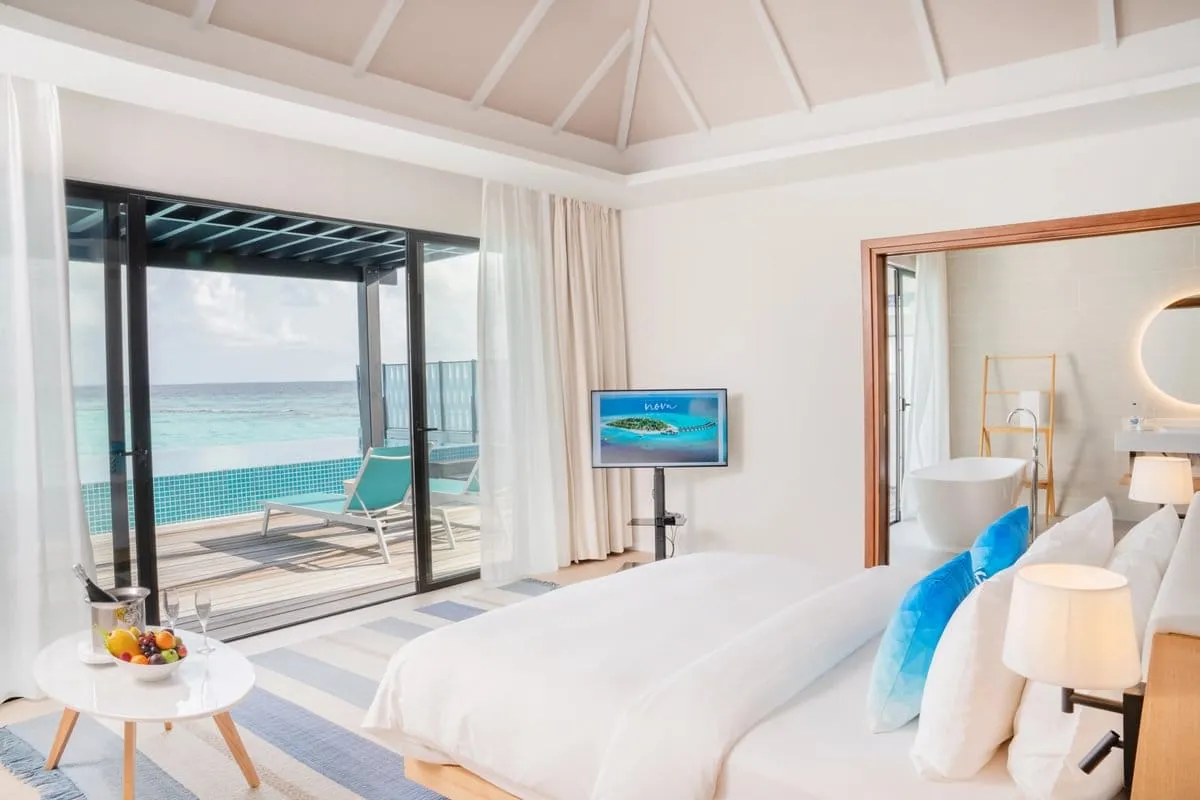 The pool beyond the bedroom glazing and lagoon in the background.