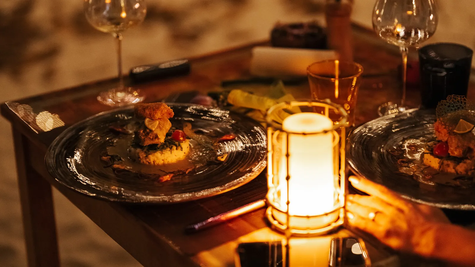Dinner at Samaasaa: decorated plates and a lit lantern on a dark table.