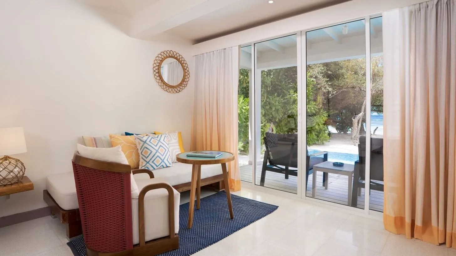 The sitting room of a Beach Suite, with its sofa and glass doors open to the veranda
