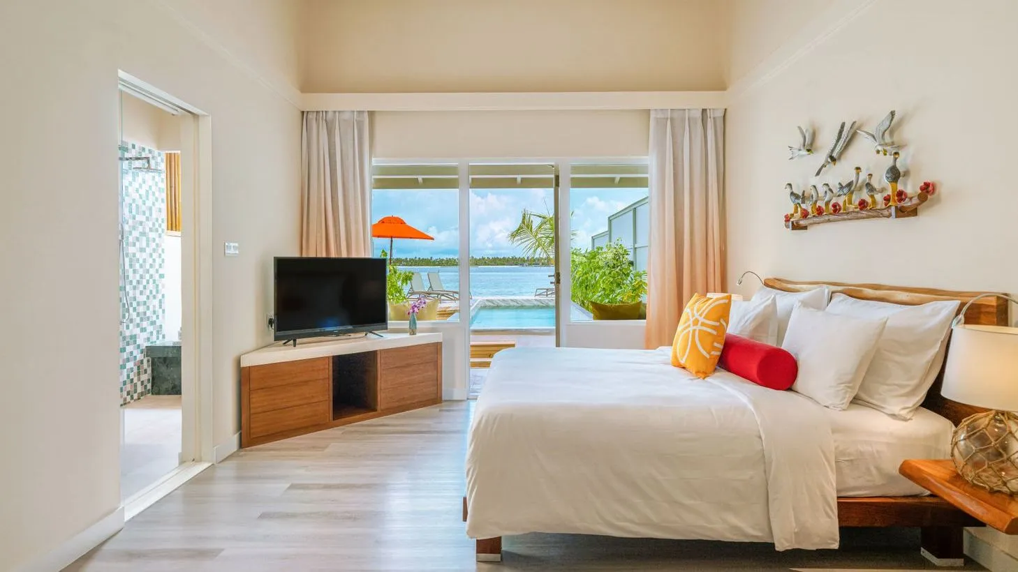 The main bedroom of the family villa, with glass doors on to the pool and a parasol