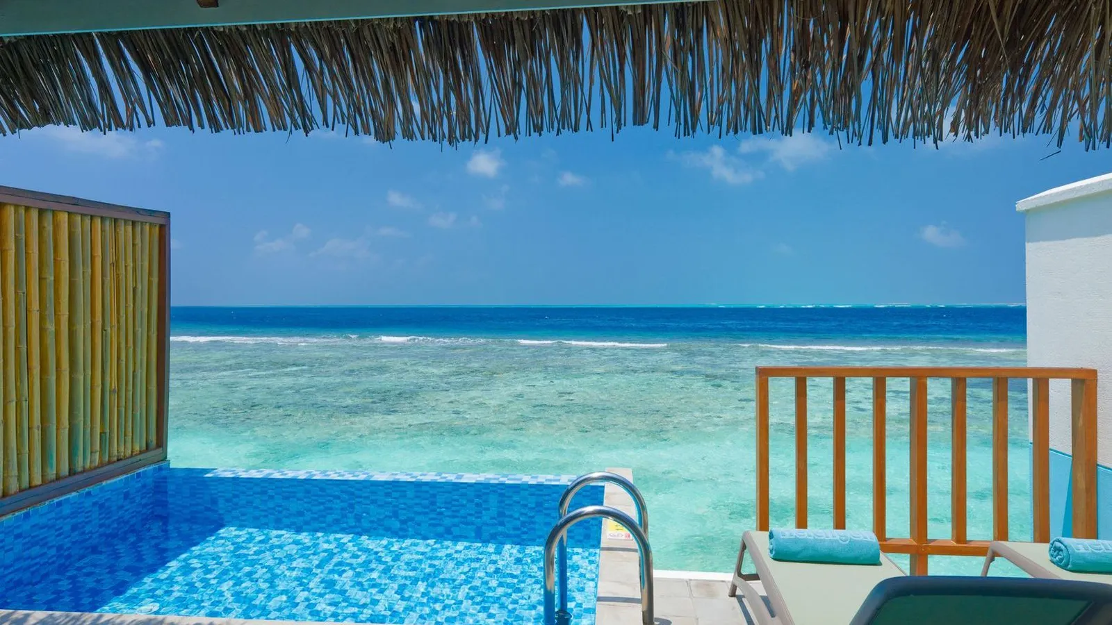 The pool of a Lagoon Villa under its thatched canopy, looking out to the ocean