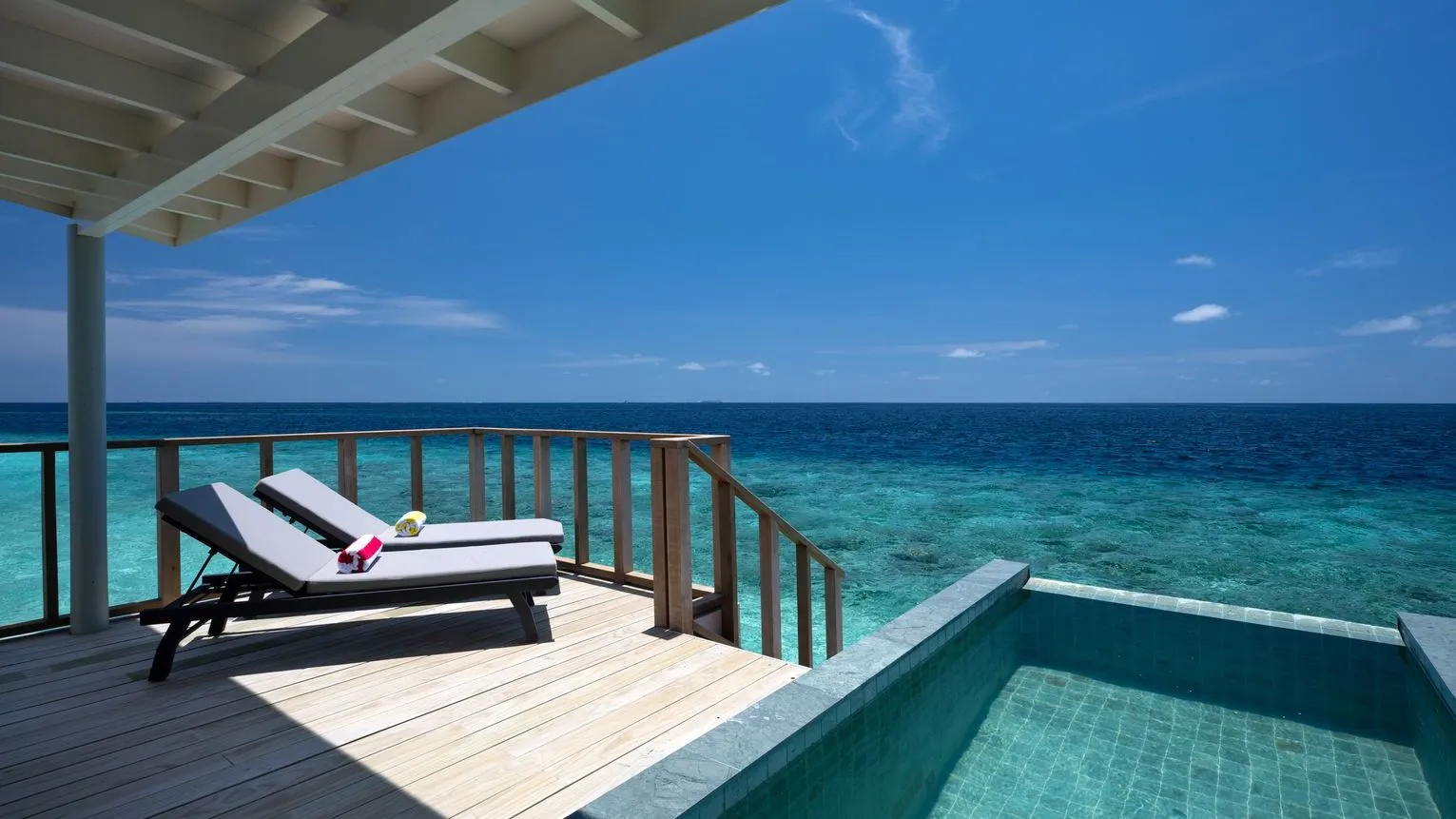 A SunNest Water Pool Villa’s deck, with its small pool, 2 loungers and the open sea.