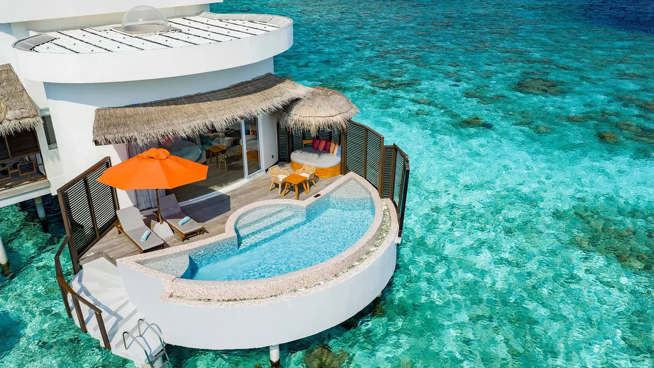 A Honeymoon SELECT Ocean Villa from above: the round pool on the deck and the turquoise lagoon around it.