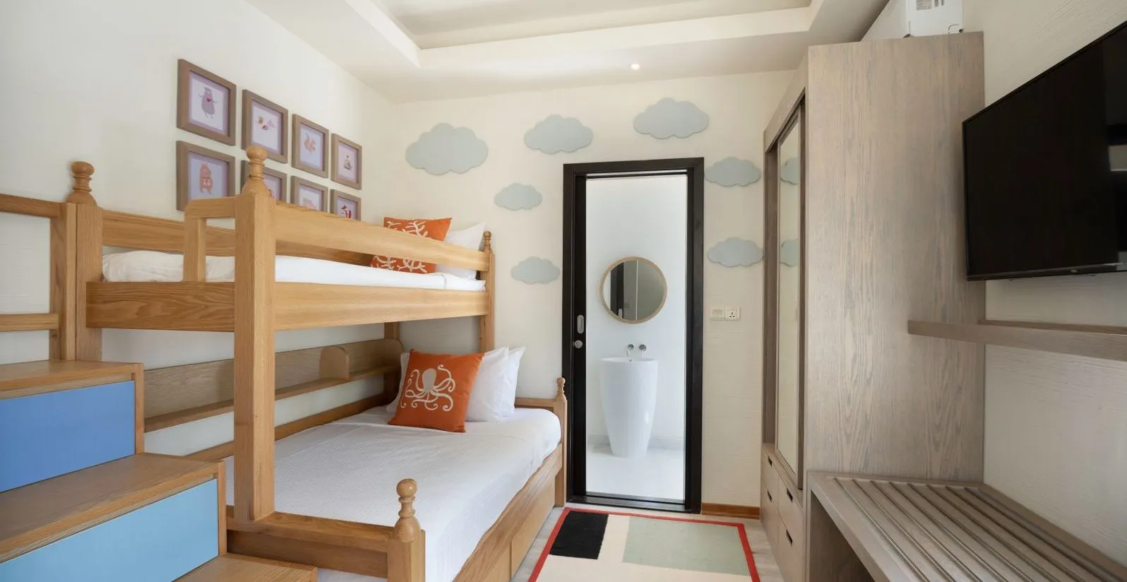 The children’s room of an Ocean View Family Two Bedroom, with its bunk bed and clouds painted on the wall.
