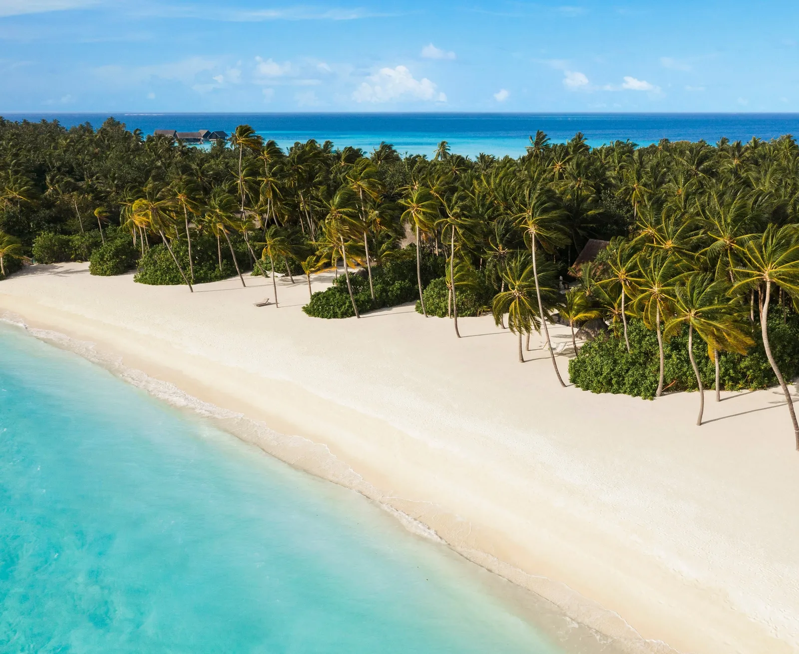 A Reethi Rah beach from the air, white sand between the palms and turquoise water
