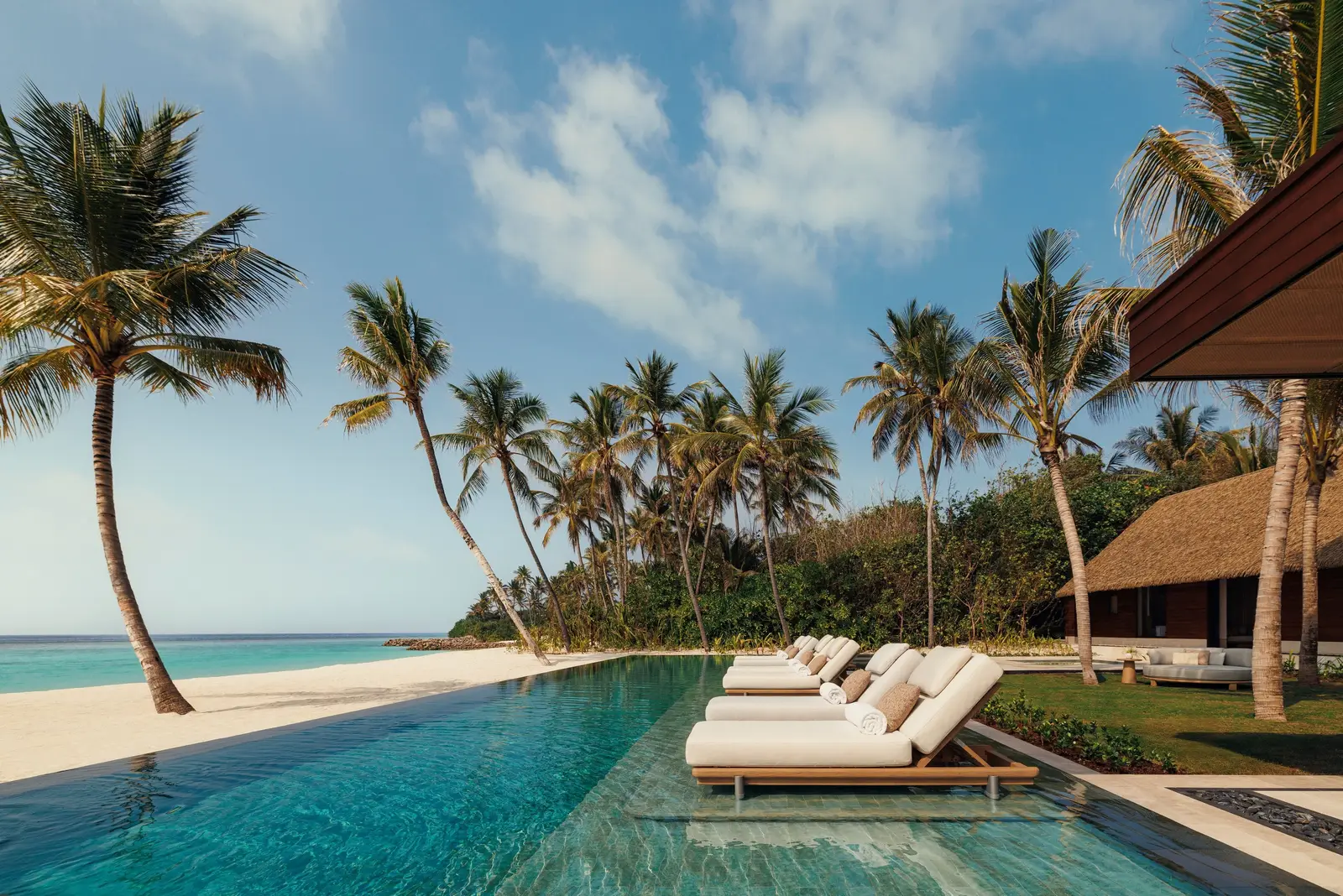 The Grand Sunset Residence’s long pool and loungers, facing the sea