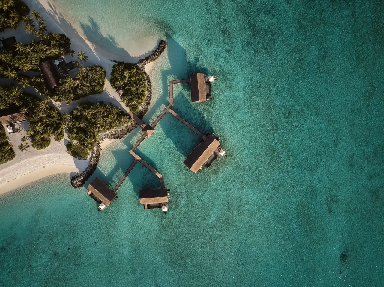 A cluster of Water Villas With Pool from the air, each with a pool on its deck