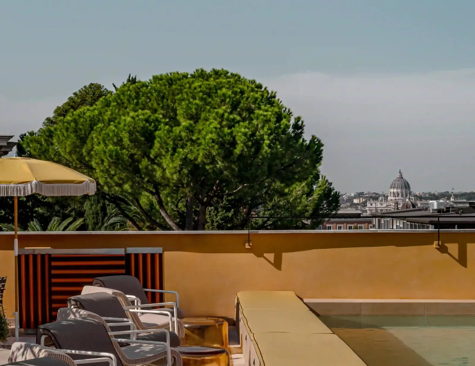 The roof terrace and pool of Experimental Roma, a stone pine and, on the horizon, the dome of St Peter’s