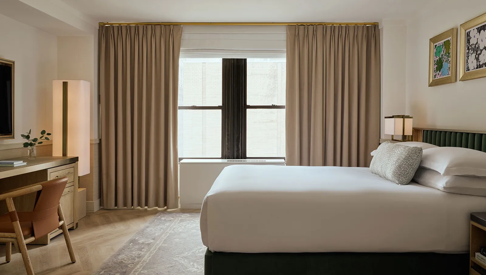 La camera del Kimpton Ashbel, con la testiera verde e il tavolo vicino alla finestra