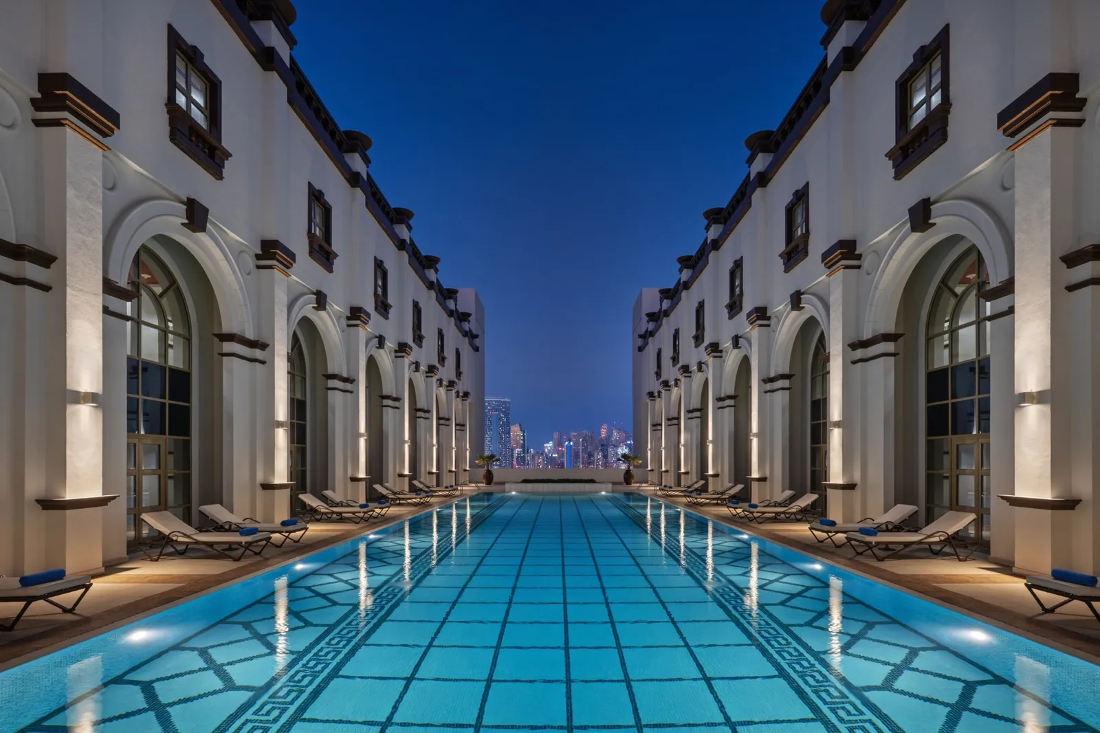The NH Collection Dubai Ibn Battuta rooftop pool illuminated at night