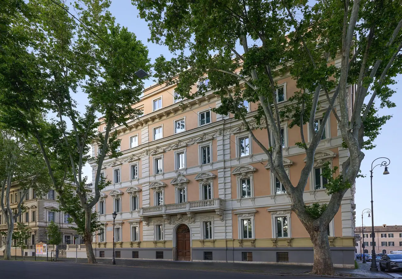 Palazzo Sanzio’s façade on the Lungotevere, among the plane trees