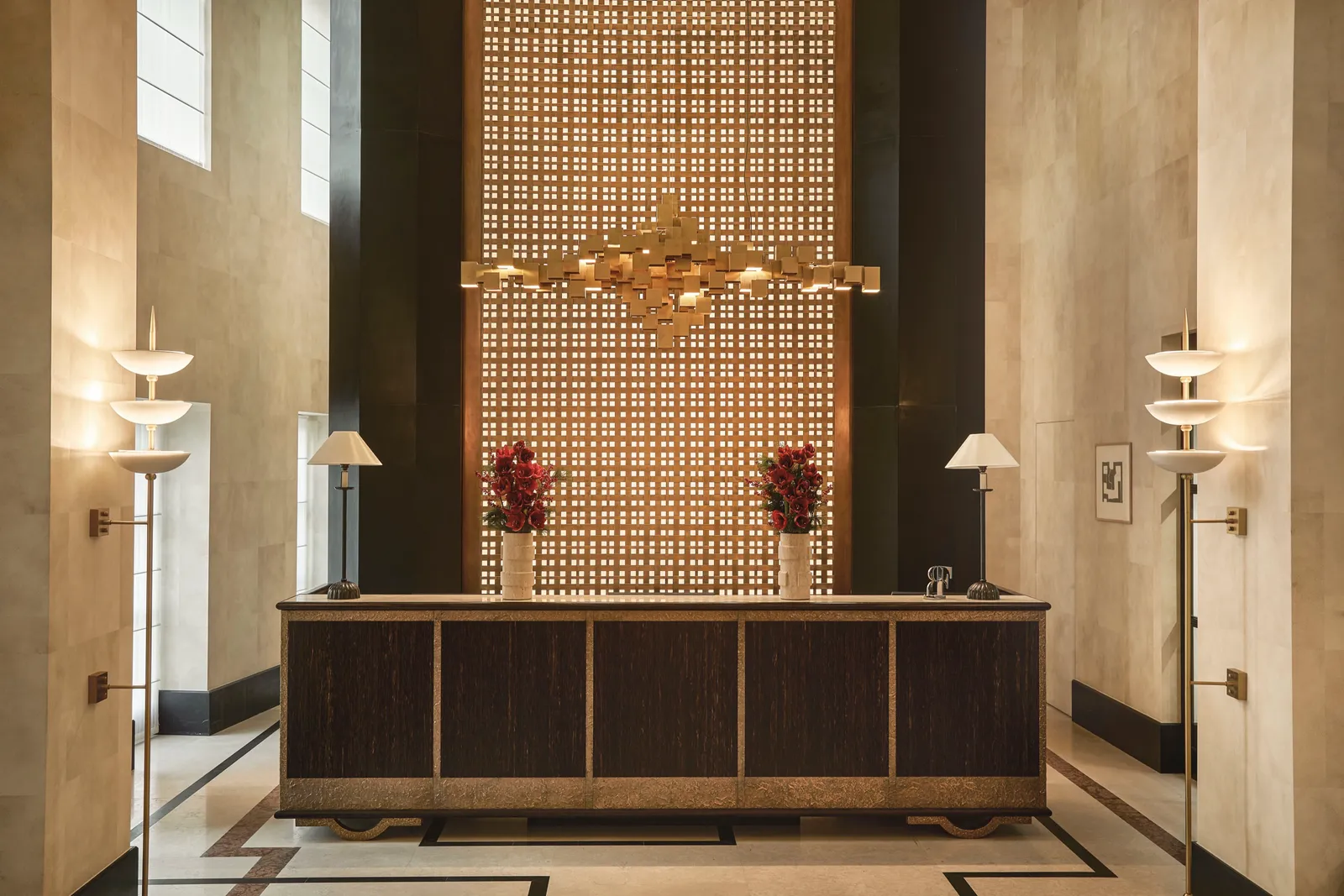The Carlton’s double-height lobby, with the brass lattice screen behind the desk