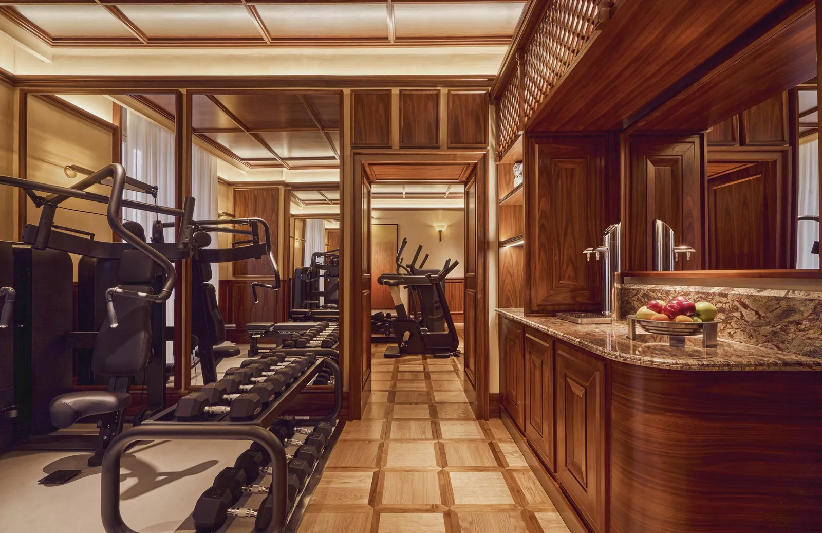 The gym with Technogym machines between wood-panelled walls
