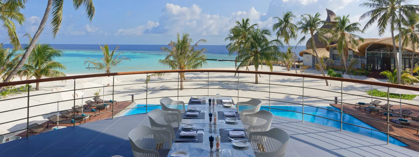 Art-I-San’s terrace, a table laid above the pool and, beyond, the beach, the palms and the sea.