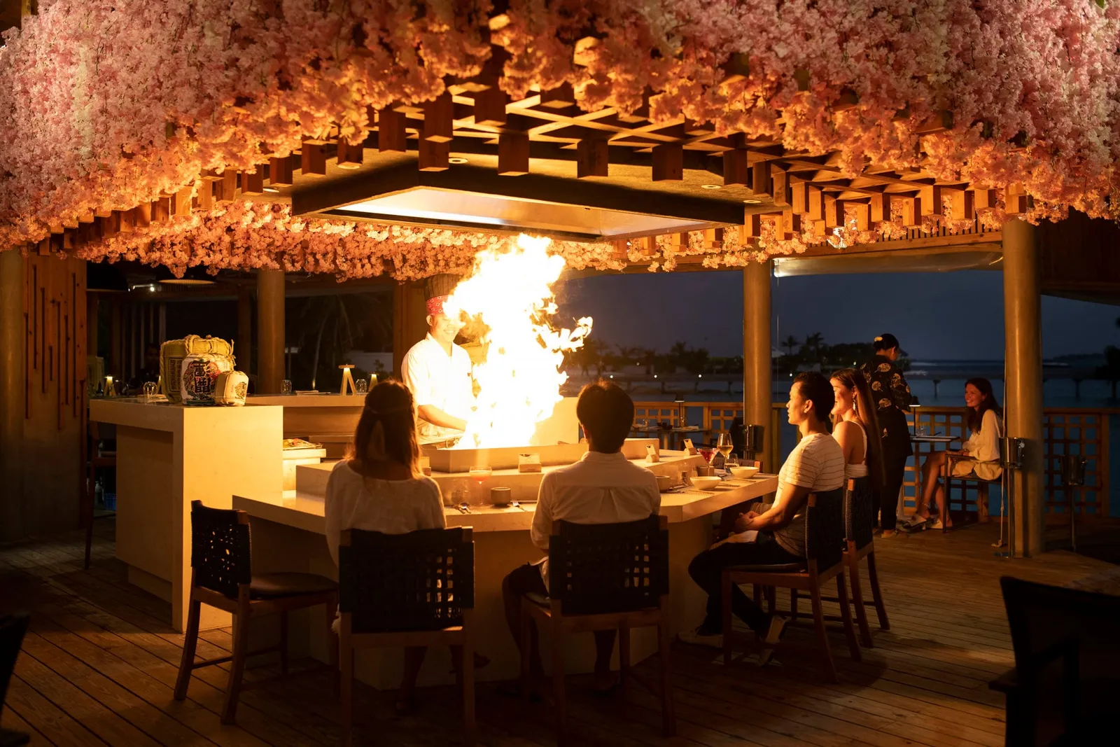 Koto’s teppanyaki counter under a ceiling of blossom: the chef sends up a burst of flame in front of the seated guests.
