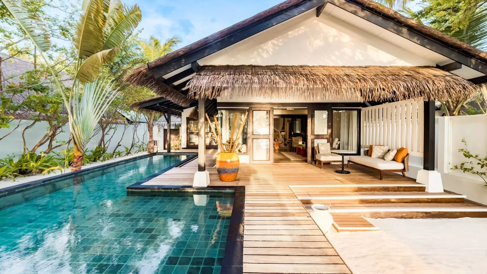 The 2-bedroom Earth Pool Pavilion, its pool in front of the timber deck and the thatched roof.