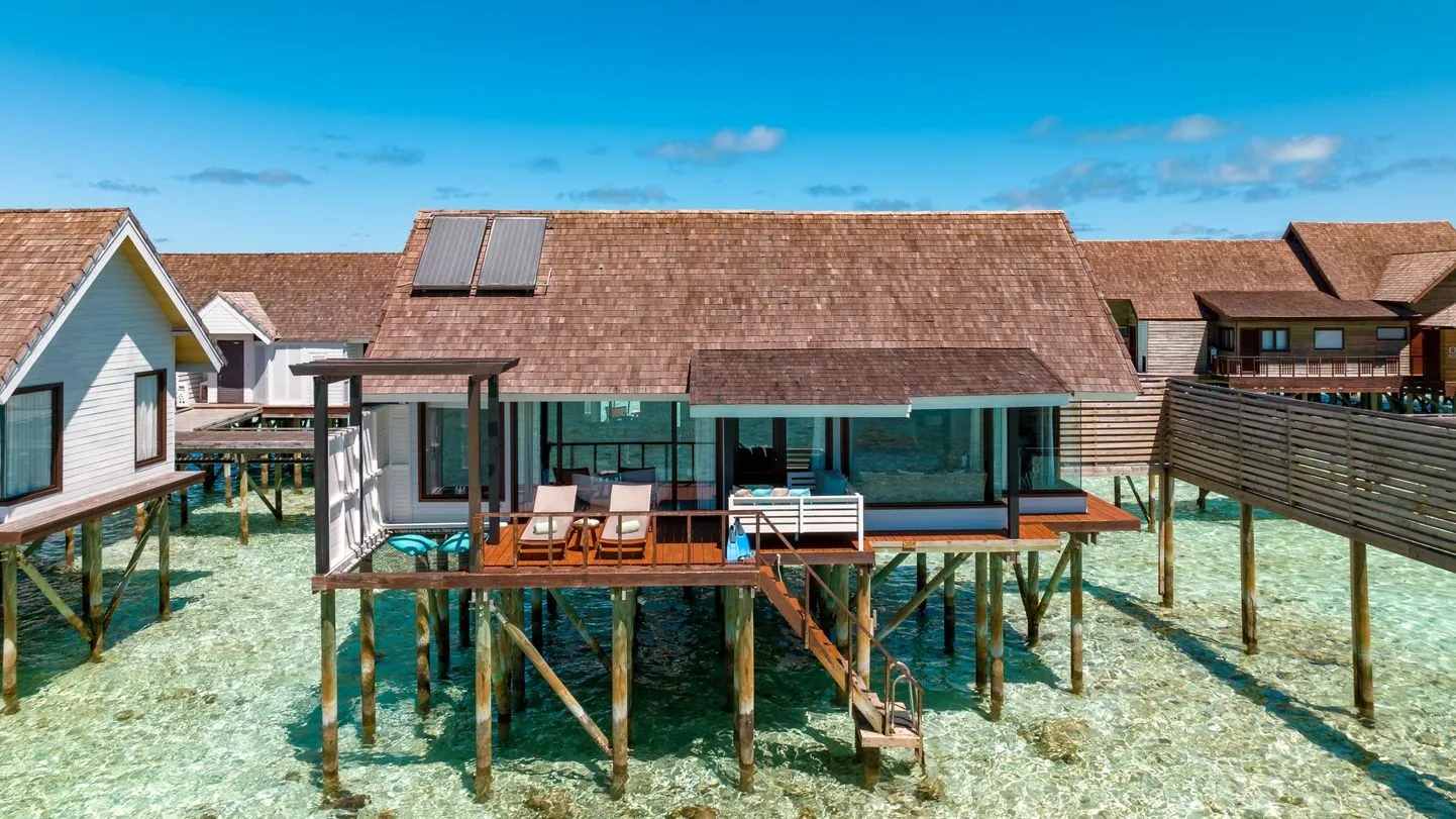 A Wind Villa on stilts over the lagoon, with its deck and the steps down into the water.