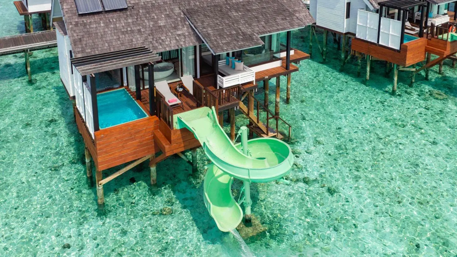 A Wind Villa with Jacuzzi & Slide from above: the hot tub and the green slide into the lagoon.