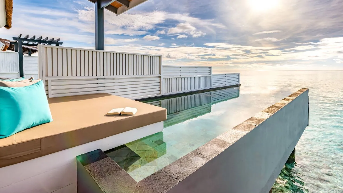 A Wind Villa with Pool’s infinity pool over the lagoon, with the daybed on the deck.