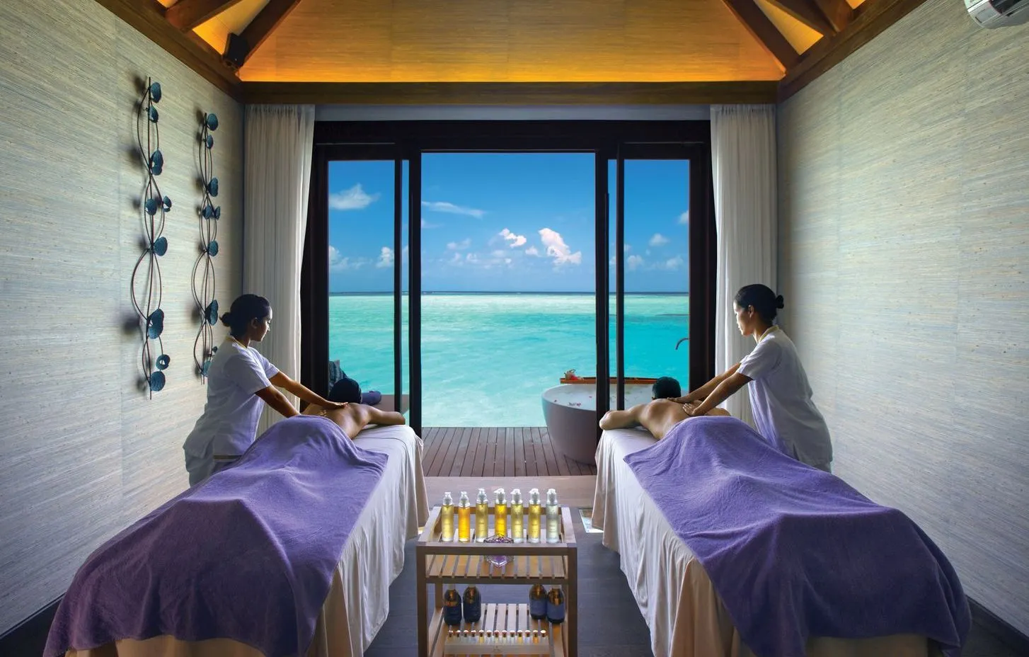 An ELE|NA spa room with 2 treatment beds and a glass wall open to the lagoon.