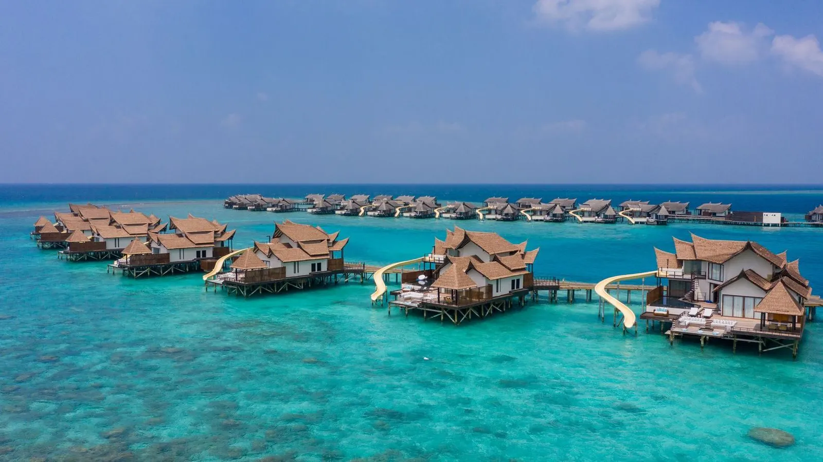 The water villas in a row on the lagoon, some with a slide running from the deck into the sea.