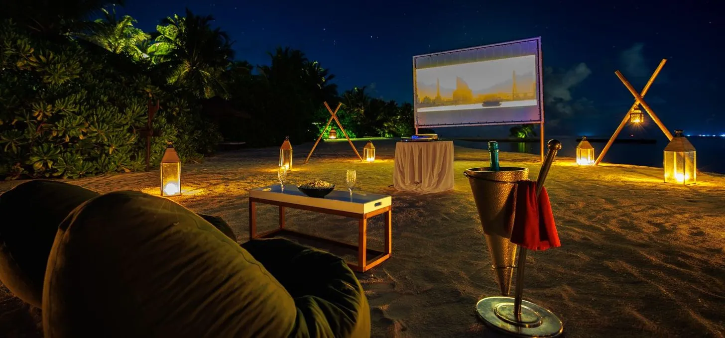 The beach cinema at night: the screen, the beanbags, the lanterns and the champagne bucket.