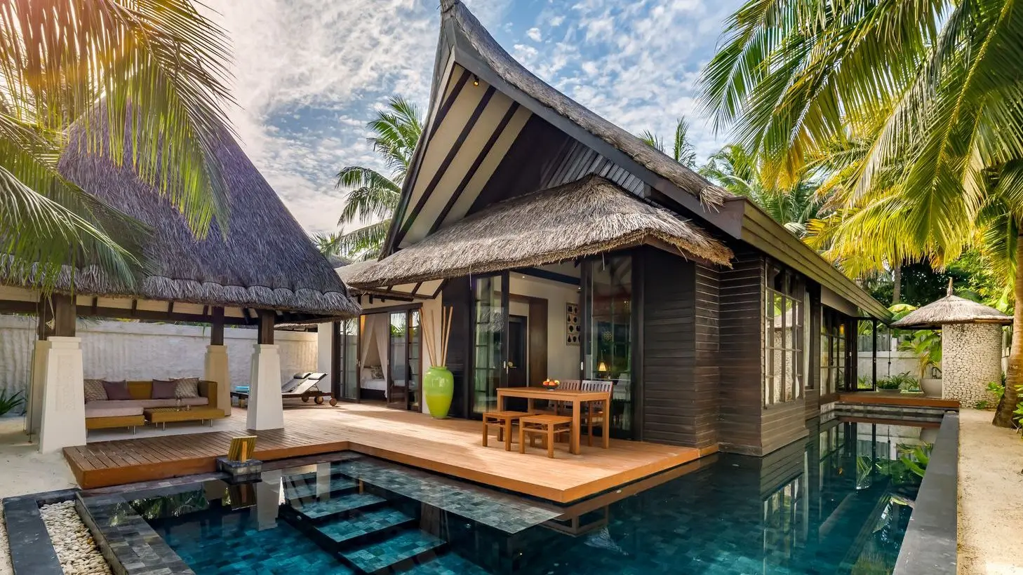 The 2-bedroom Earth Pool Pavilion, with its covered deck, pool and thatched roof.