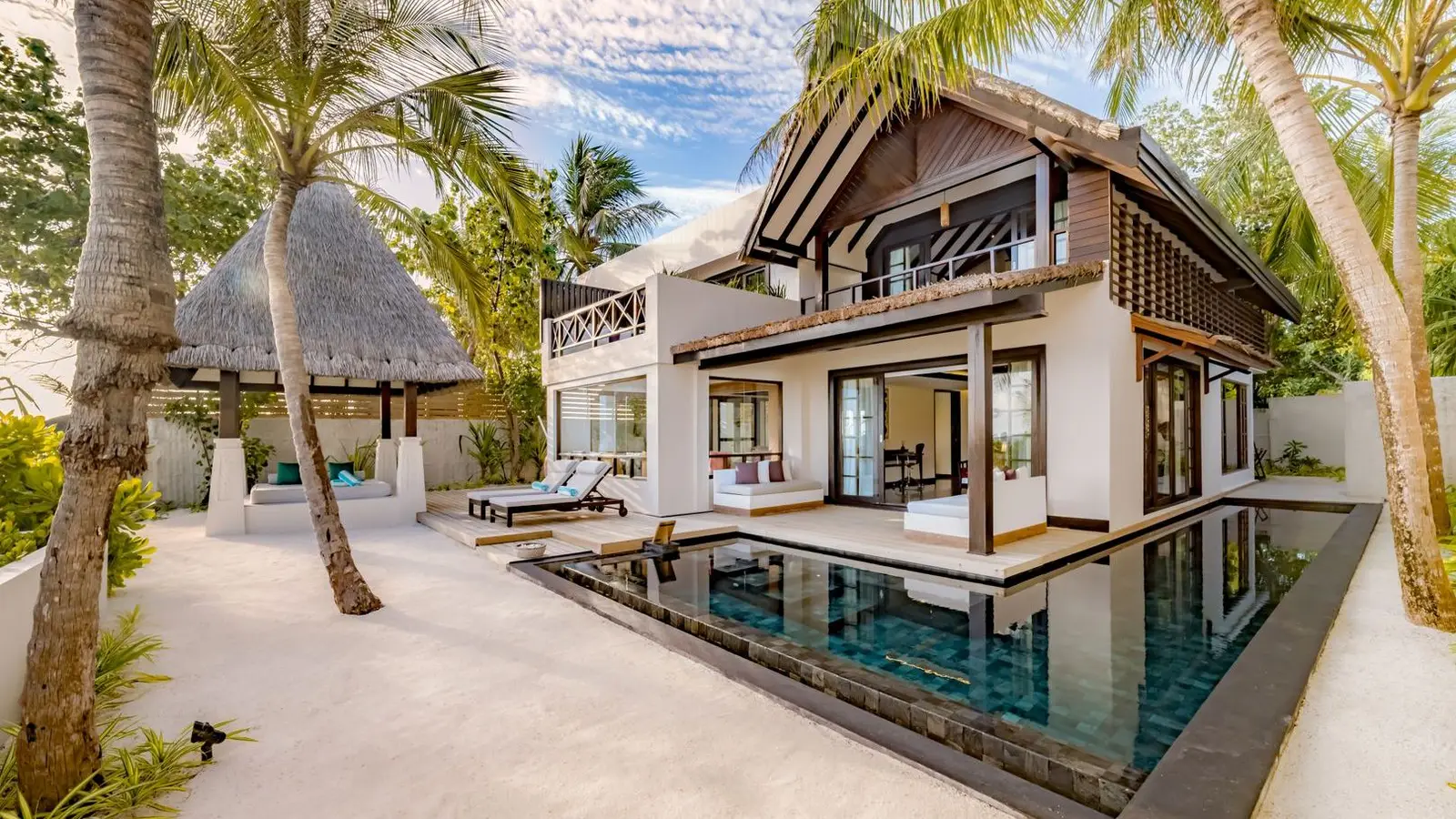 The 3-bedroom Earth Pool RESERVE among the palms, its pool in front and a terrace upstairs.