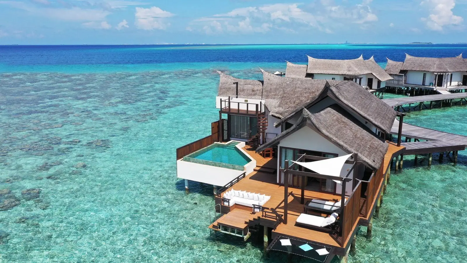 An Ocean Pool Suite from above, with the pool on its deck and the clear lagoon around it.